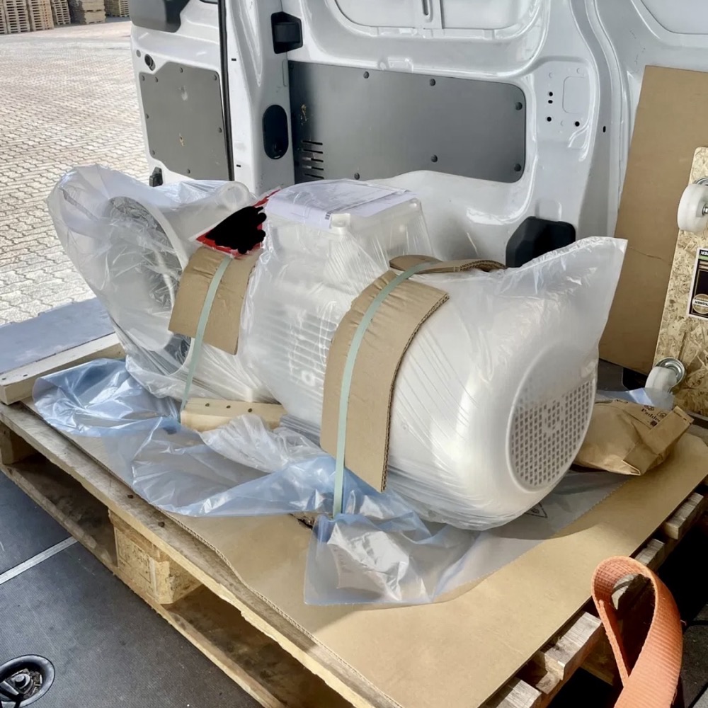 Verpackte Maschine auf Palette beim Verladen in den Transporter